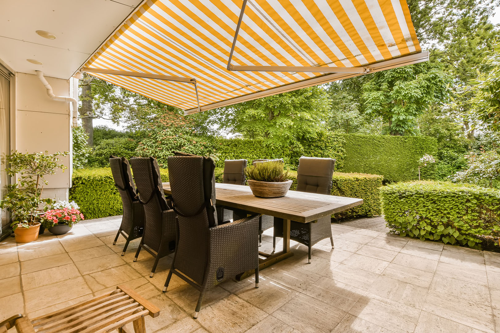 Outdoor dining patio area beneath a retractable fabric awning